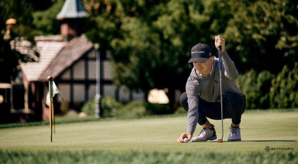 A golfer holding a Bettinardi Queen B 16 golf putter